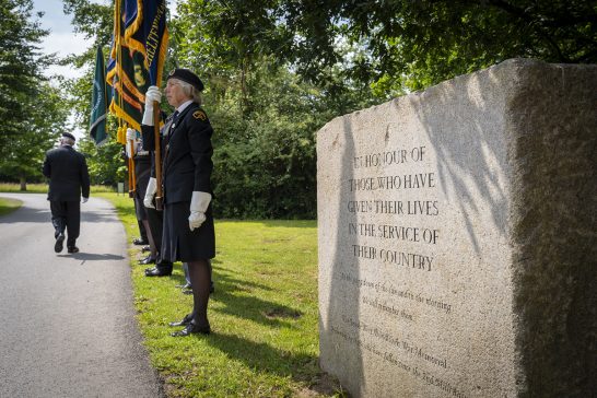 Veterans stand in solemn remembrance at the Memorial Stone, honoring those who served with a moment of reflection
